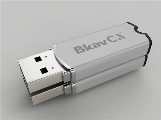 USB Token BkavCA màu bạc đặt trên gương, phần bên dưới là ảnh phản chiếu của cùng thiết bị